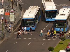 peatones cruzando la calle con la app sin instalación autobuses esperando en semáforo en rojo a que pasen los peatones