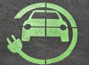 Charging spot of an electric car Green color symbol of an electric car painted on the asphalt in a charging spot