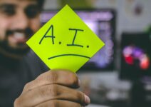 Una persona sujetando un post-it que dice A.I.